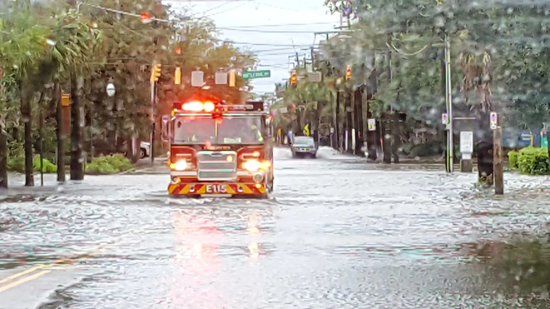 A fire engine drives through a flooded downtown Charleston street under storm-tossed traffic signals after Hurricane Matthew.
